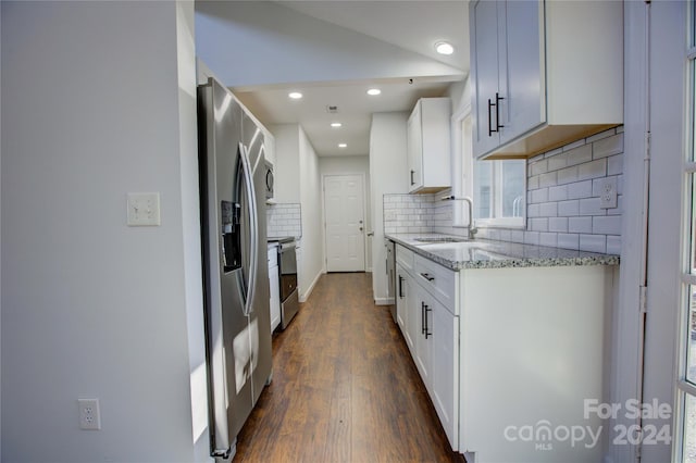 kitchen featuring dark wood-type flooring, sink, decorative backsplash, white cabinetry, and stainless steel appliances