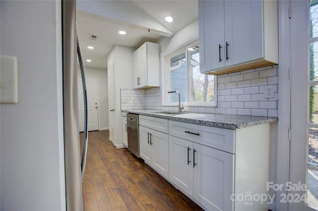 kitchen with light stone countertops, backsplash, dark wood-type flooring, sink, and white cabinets