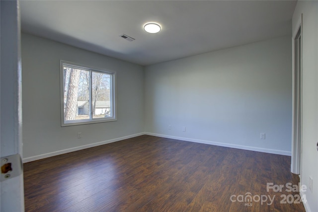 unfurnished room with dark hardwood / wood-style flooring