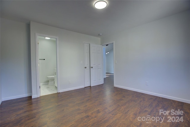 unfurnished bedroom with dark wood-type flooring and ensuite bath