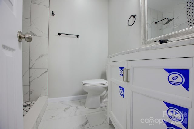 bathroom with vanity, toilet, and a tile shower