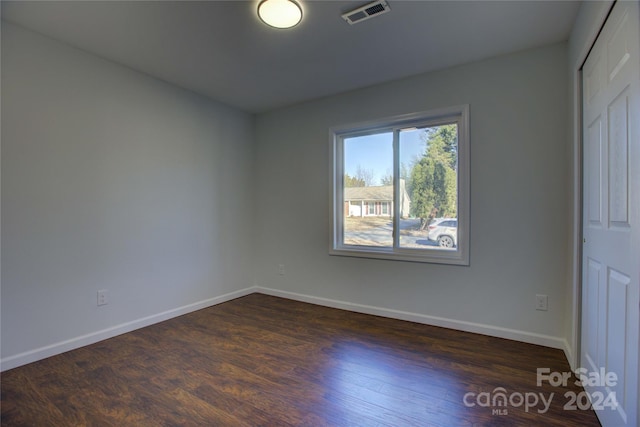 unfurnished room featuring dark wood-type flooring