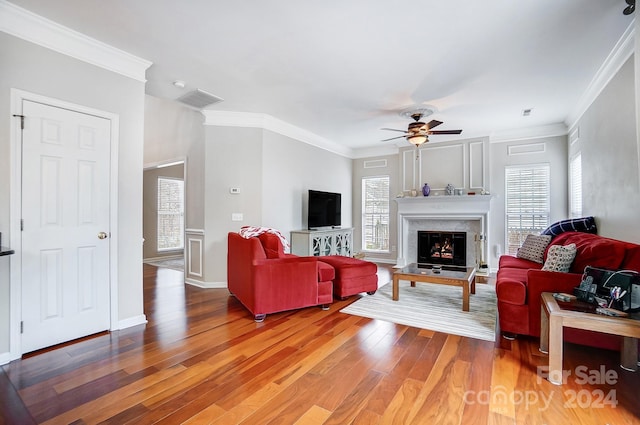 living room featuring wood-type flooring, ceiling fan, and crown molding