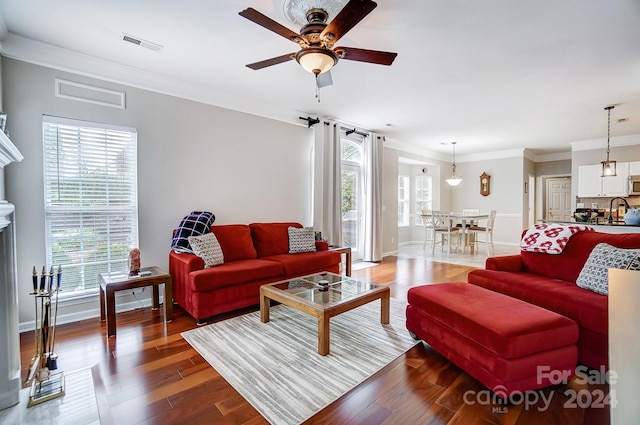 living room with hardwood / wood-style flooring, plenty of natural light, ceiling fan, and ornamental molding