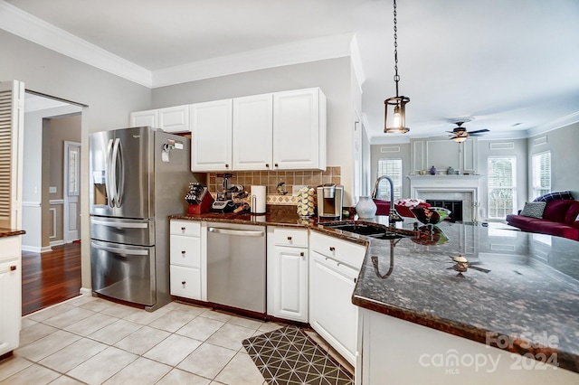 kitchen with pendant lighting, white cabinetry, sink, and appliances with stainless steel finishes