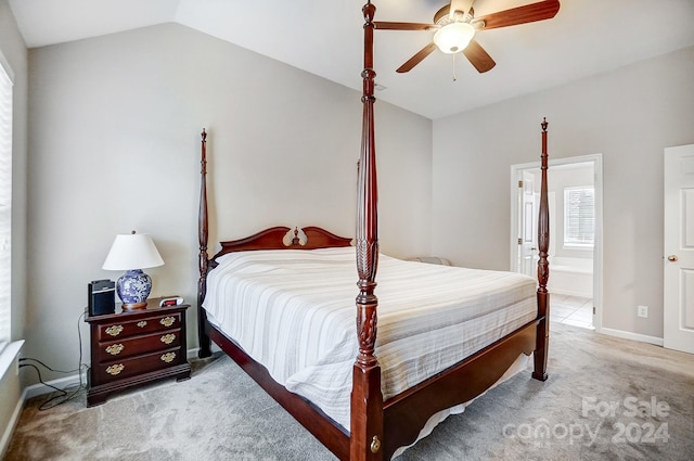 bedroom featuring light carpet, ensuite bathroom, ceiling fan, and lofted ceiling