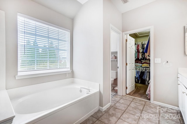 bathroom with tile patterned floors, vanity, toilet, and a bath