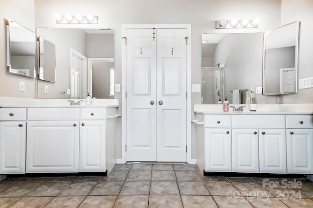 bathroom with tile patterned flooring, vanity, and an enclosed shower