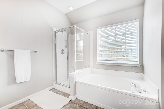 bathroom with tile patterned floors, separate shower and tub, and vaulted ceiling