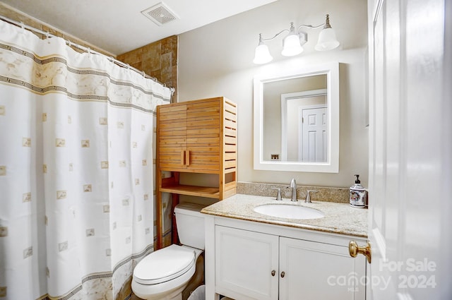 bathroom with a shower with shower curtain, vanity, and toilet