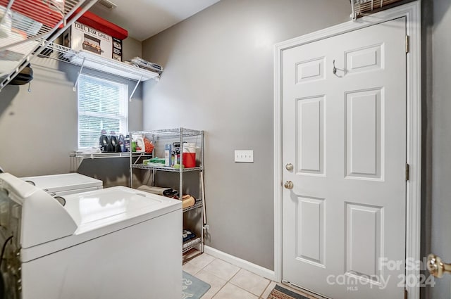 clothes washing area featuring light tile patterned floors and independent washer and dryer