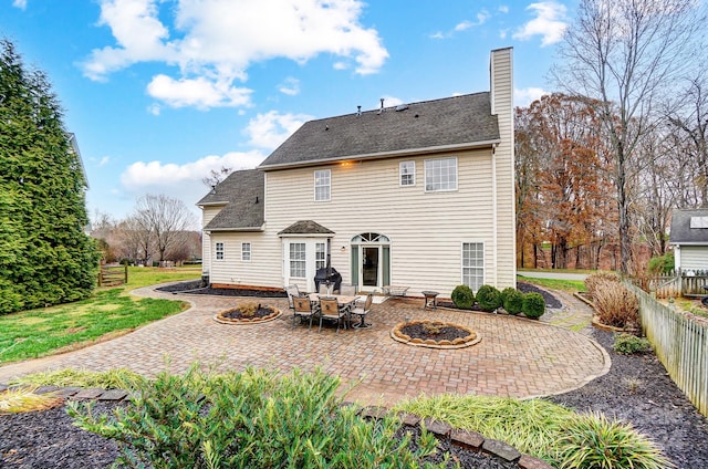 back of house with a fire pit and a patio