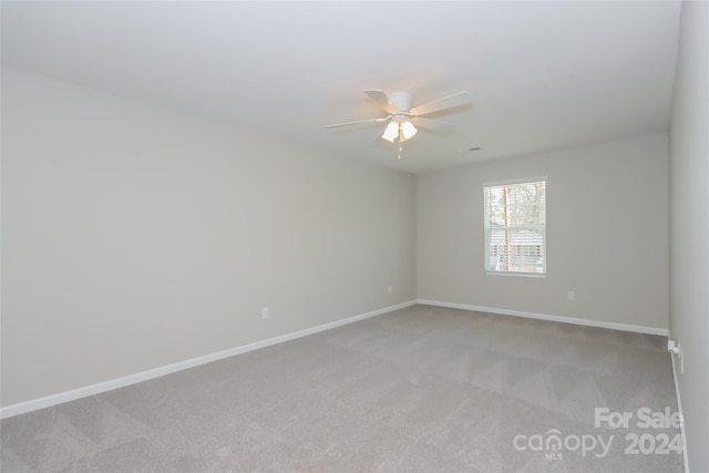 carpeted spare room with ceiling fan