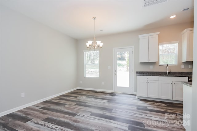 kitchen featuring white cabinetry, plenty of natural light, dark hardwood / wood-style floors, and an inviting chandelier