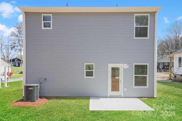 back of property with a lawn, a patio area, and central AC unit