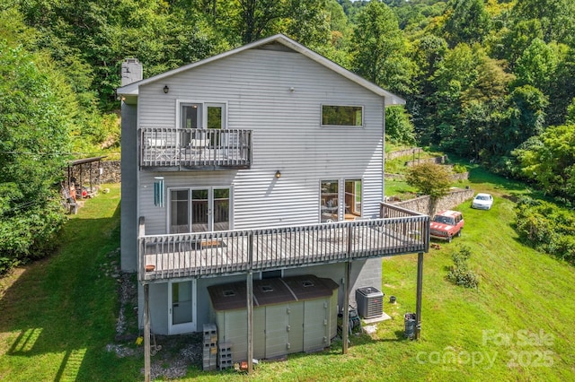 back of house with a lawn, central air condition unit, and a wooden deck