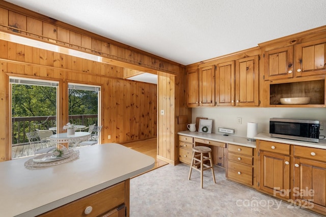 kitchen featuring a textured ceiling and wooden walls