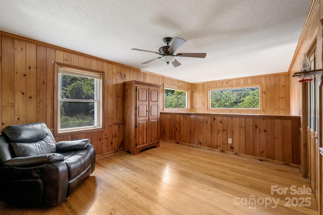 sitting room with ceiling fan, light hardwood / wood-style flooring, and a healthy amount of sunlight