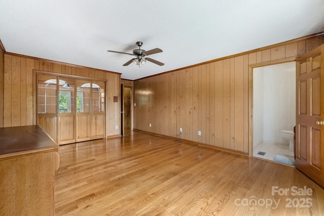 unfurnished living room with ceiling fan, light hardwood / wood-style flooring, and ornamental molding