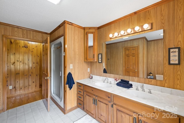 bathroom with vanity, wood walls, tile patterned floors, ornamental molding, and a textured ceiling