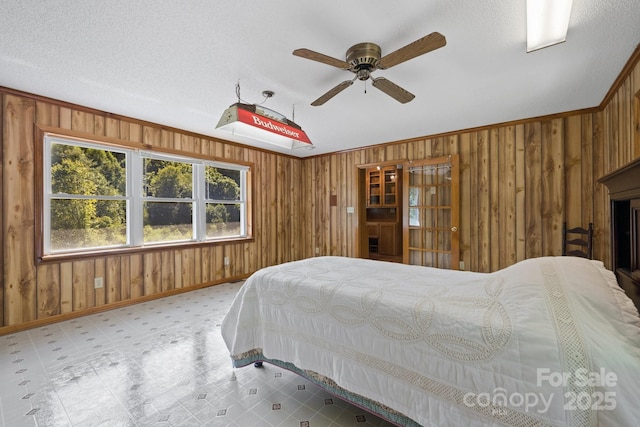 bedroom with ceiling fan and wooden walls