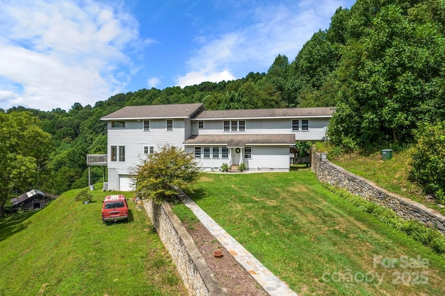 back of property with a yard and a garage