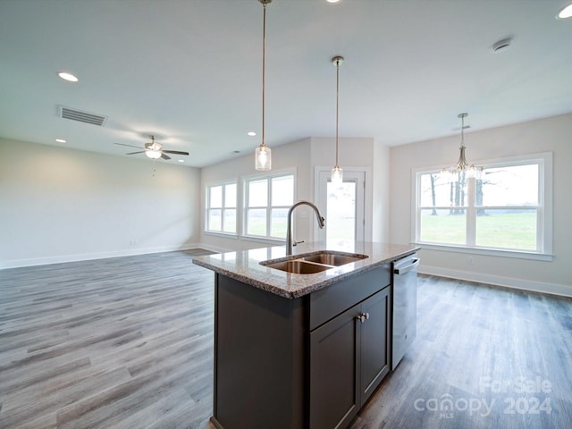 kitchen featuring hardwood / wood-style flooring, light stone counters, a healthy amount of sunlight, and sink