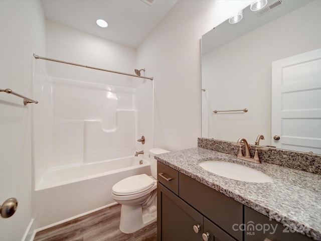 full bathroom featuring hardwood / wood-style floors, vanity, toilet, and bathtub / shower combination