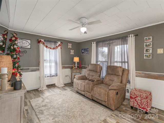 living room featuring plenty of natural light, light wood-type flooring, and ornamental molding