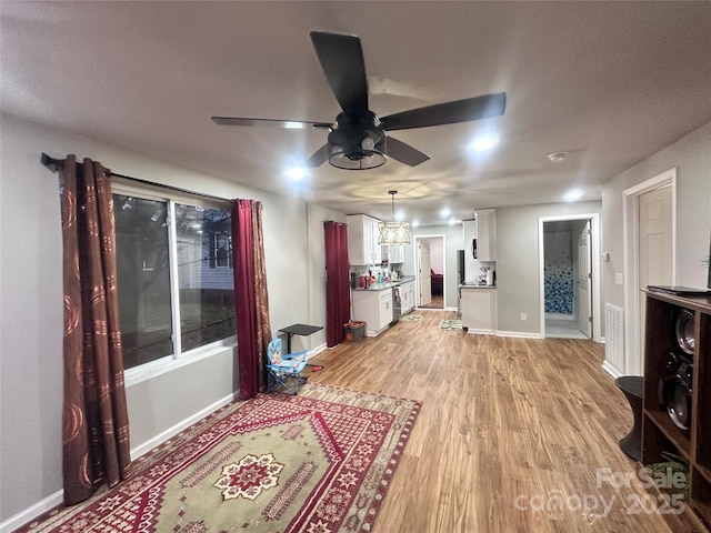 living room with ceiling fan and light wood-type flooring