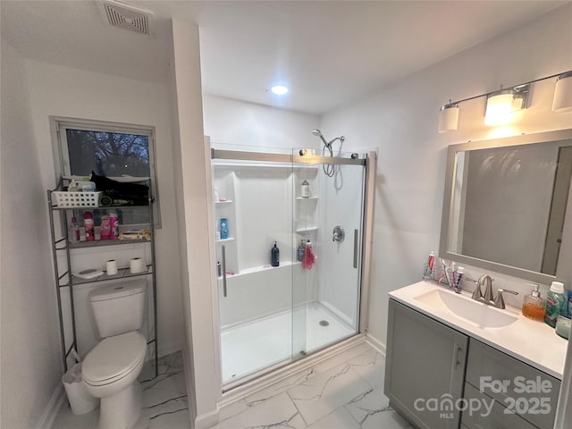 bathroom with vanity, toilet, and a shower with shower door