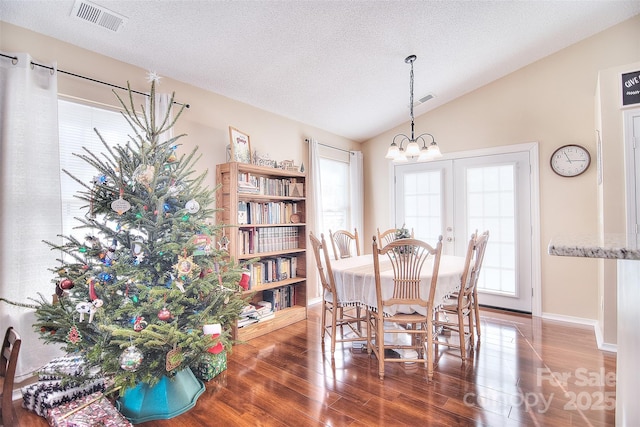3076 Champion Ln SW, Concord, NC 28025 - dining room with wood finished floors, vaulted ceiling, a chandelier, and a textured ceiling