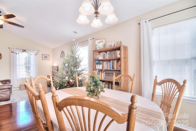 3076 Champion Ln SW, Concord, NC 28025 - dining room featuring wood finished floors, a chandelier, lofted ceiling, and ceiling fan