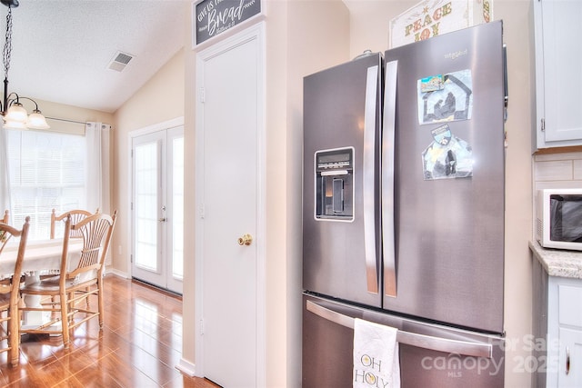 3076 Champion Ln SW, Concord, NC 28025 - kitchen featuring stainless steel fridge, light wood-type flooring, vaulted ceiling, pendant lighting, and a textured ceiling