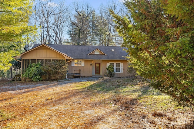 view of front of house featuring a sunroom and a front lawn