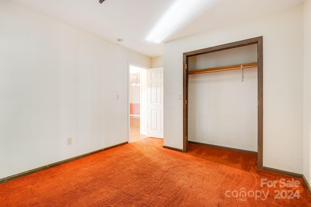 unfurnished bedroom featuring carpet and a closet