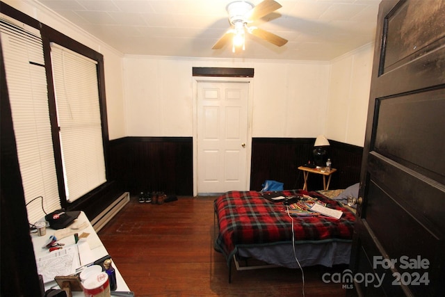 bedroom with crown molding, wooden walls, ceiling fan, dark hardwood / wood-style floors, and a baseboard radiator