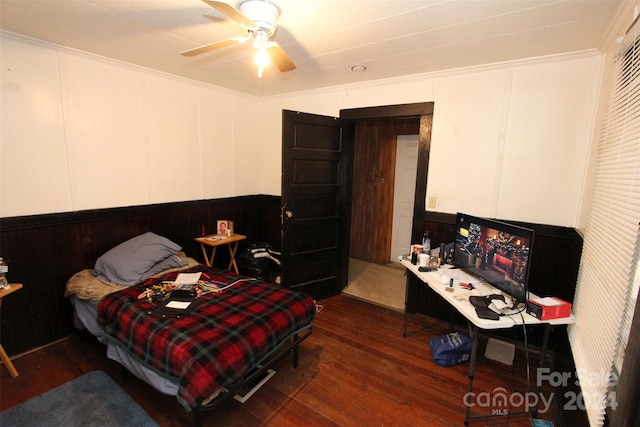 bedroom with crown molding, ceiling fan, and dark wood-type flooring