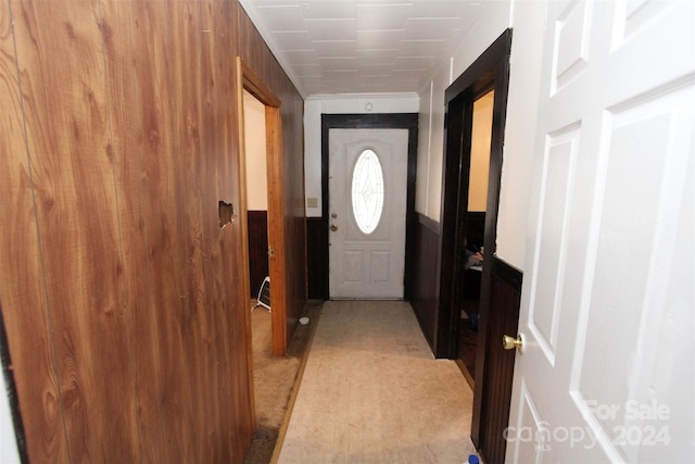 doorway to outside featuring wood walls