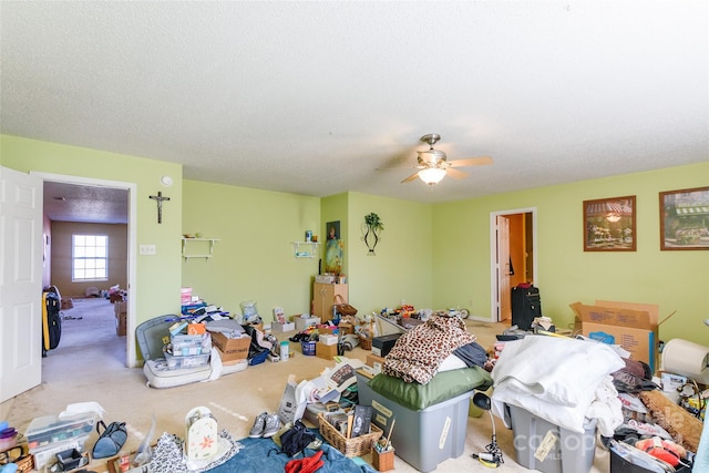 miscellaneous room featuring carpet flooring, ceiling fan, and a textured ceiling