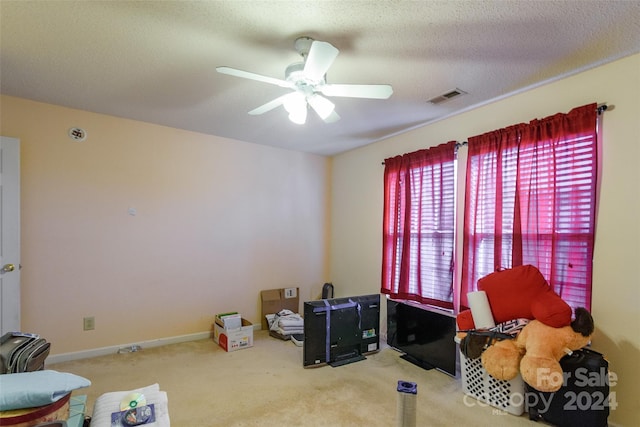 misc room with a textured ceiling, carpet floors, and ceiling fan