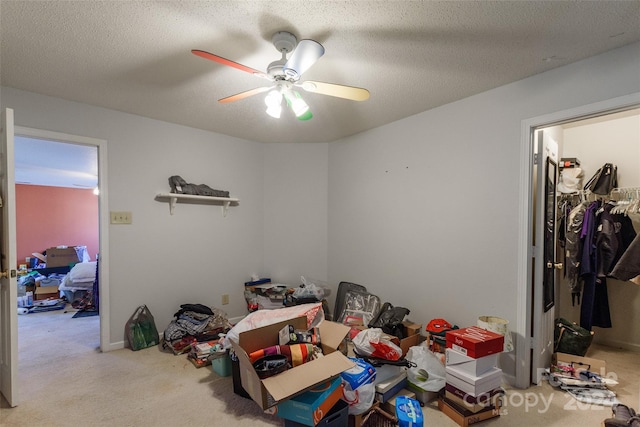 carpeted bedroom with ceiling fan, a textured ceiling, and a closet