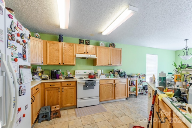 kitchen featuring pendant lighting, white appliances, sink, light tile patterned floors, and a textured ceiling