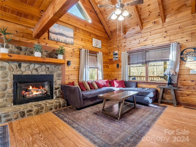 living room featuring beam ceiling, high vaulted ceiling, a fireplace, wood ceiling, and light wood-type flooring