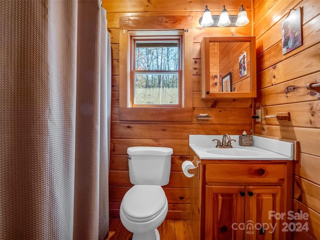 bathroom with a shower with shower curtain, vanity, toilet, and wood walls