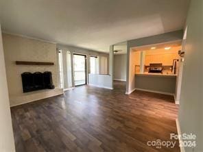 unfurnished living room with a fireplace and dark wood-type flooring