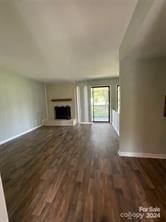 unfurnished living room with dark wood-type flooring