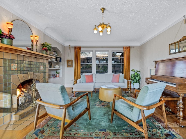 living room featuring hardwood / wood-style floors, a textured ceiling, an inviting chandelier, and ornamental molding