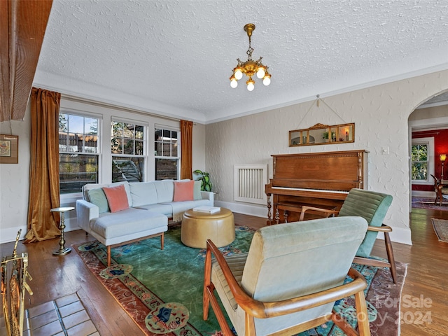 living room with a textured ceiling, hardwood / wood-style flooring, and an inviting chandelier