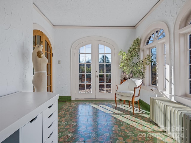 doorway with radiator, french doors, a textured ceiling, and ornamental molding